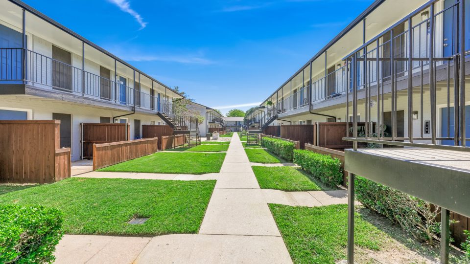 apartment complex with walkway and grass at The Canyon Creek Apartments