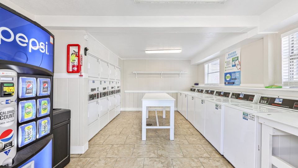 a laundry room with a vending machine and a washer at The Canyon Creek Apartments